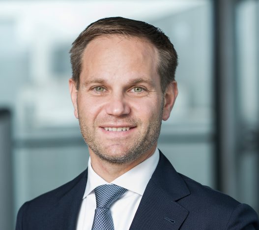 Portraitfoto von Matthias Unger, CEO und Eigentümer, Ein Mann in Anzug und Krawatte, lächelnd